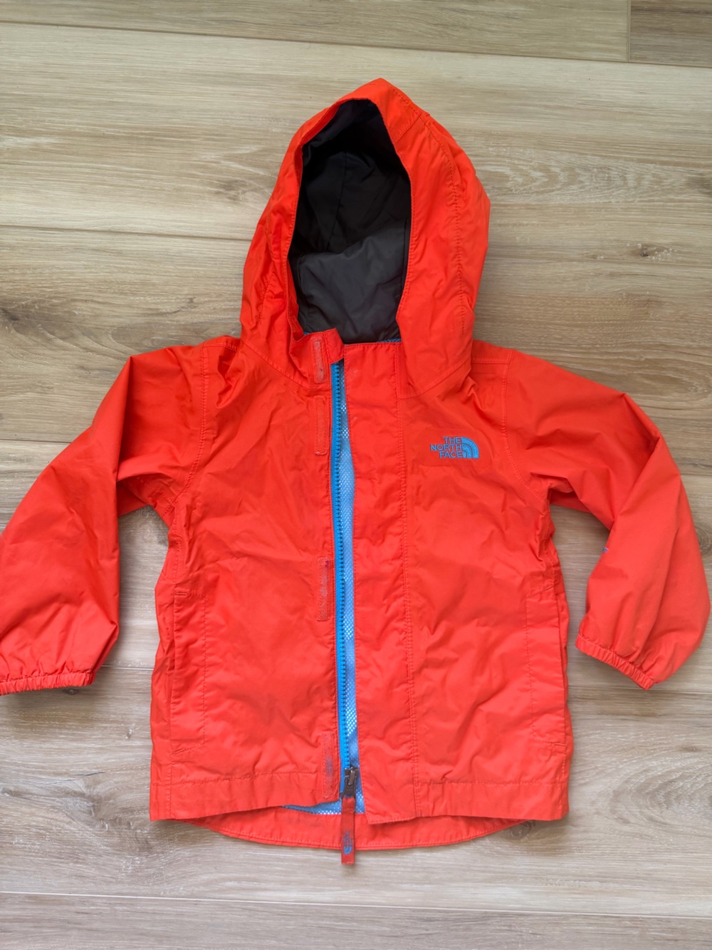 The North Face Kids Orange Hooded Windbreaker with Blue Zipper